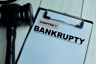 Concept of Chapter 7 - Bankrupty write on paperwork with gavel isolated on wooden background. clipart