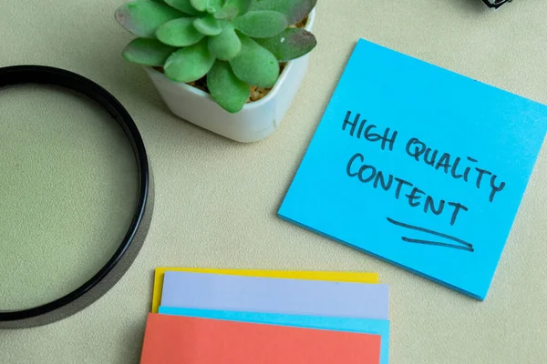 Concept of High Quality Content write on sticky notes isolated on Wooden Table.