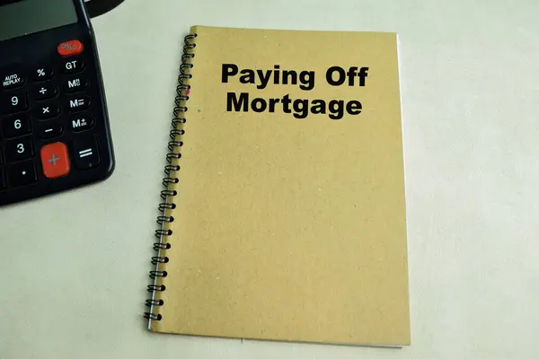 Concept of Paying Off Mortgage write on book isolated on Wooden Table.