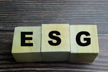 Ahşap arka planda ESG sözcüğü olan tahta küplerin kavramı.