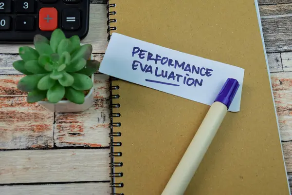 Concept of Performance Evaluation write on sticky notes isolated on Wooden Table.