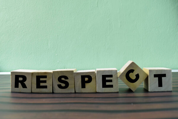 Concept of The wooden Cubes with the word Respect on wooden background.