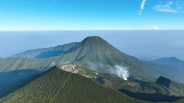 Sabahları sislerin altındaki dağların havadan görünüşü. Java Adası 'ndaki Gede Pangrango manzarası. Bogor, Endonezya. 18 Şubat 2024