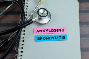 Ankylosing Spondylitis kavramı yapışkan notlara yazılır ve steteskop Tahta Masa 'da izole edilir.