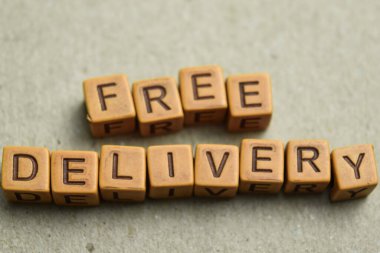 Tahta bloklara yazılmış ücretsiz teslimat mesajı kavramı. Ahşap Arkaplanda işlenmiş resmi karşılaştır