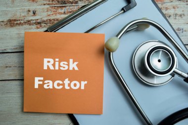 Risk faktörü kavramı yapışkan notlara yazılır ve steteskop ahşap masa üzerinde izole edilir.