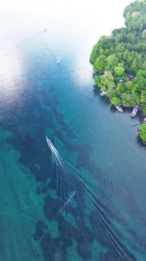 Gün batımında Banda Neira körfezindeki ahşap bir teknenin hava takibi. Maluku, Endonezya, 19 Nisan 2024