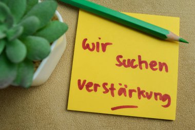 Wir suchen verstarkung kavramı Tahta Masa 'ya izole edilmiş yapışkan notlara yazılır.