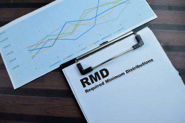 Concept of RMD - Required Minimum Distributions write on paperwork isolated on wooden background. clipart