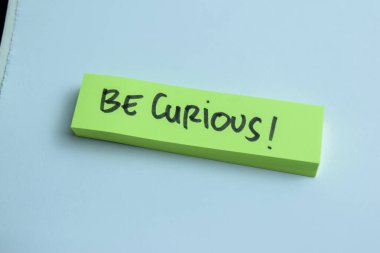 Meraklı Olma kavramı, Tahta Masa 'da izole edilmiş yapışkan notlara yaz.