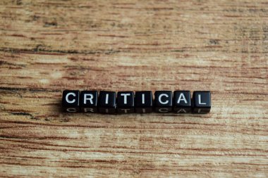 Tahta bloklara yazılmış eleştirel kavram. Ahşap Arkaplanda işlenmiş resmi karşılaştır