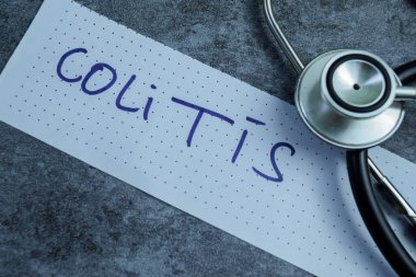 Tahta Masa 'da izole edilmiş yapışkan notlara Kolit kavramı.