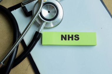Tahta Masa 'da izole edilmiş yapışkan notlara NHS kavramı.