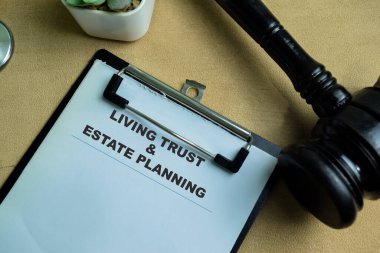 Concept of Living Trust and Estate Planning write on paperwork isolated on wooden background. clipart