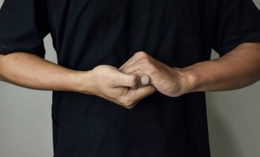 Bej arka planda işaret dili kullanan genç sağır ve dilsiz adam.