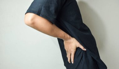 Elleri kalçasında siyah gömlek giyen bir adam.