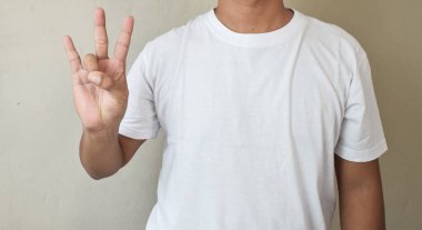 İşaret dilinde yedi numara anlamına gelirken bir adam el işaretleriyle imzalar.