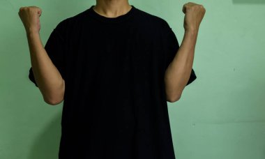 Yeşil arka planda kendini gösteren kendine güvenen genç adam.