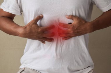 Gri arka planda mide sorunları olan bir adam.