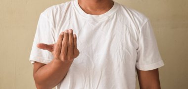 Çıplak manikürlü genç adam işaret dilini gösteren elini kaldırıyor.