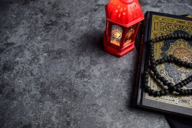 Kutsal Kur 'an, tespih, altın ramadhan lambası, koyu arkaplanda islami tespih boncukları. İslam kavramı