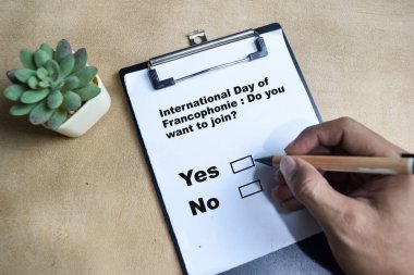 Katılmak ister misin? Evet ya da Hayır Uluslararası Francophonie Günü Tahta Masa 'da izole edilmiş evraklara yaz.
