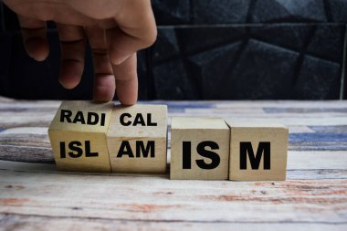 Radikalizm ya da İslamcılık kavramını kavramsallaştır. Küplere dönüşür ve radikalizm kelimesini tahta bir masanın üzerindeki tahta bloklarda İslamcılığa çevirir.