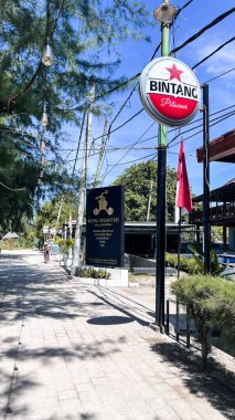 Plajda palmiye ağacıyla bira içme tabelası. Bintang Birası Endonezya 'nın popüler bir bira markasıdır. Lombok, Endonezya, 16 Nisan 2025