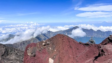 Bulutları ve vadiyi gören kayaların ve bitkilerin arasında yürüyüş yapmak.