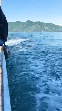 Denizin üzerinde sabahın erken saatlerinde gün doğumu. Bazı bulutlar.