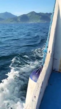 Denizin üzerinde sabahın erken saatlerinde gün doğumu. Bazı bulutlar.