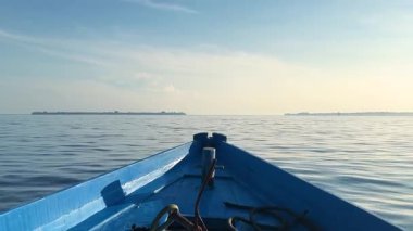 Denizin üzerinde sabahın erken saatlerinde gün doğumu. Bazı bulutlar.