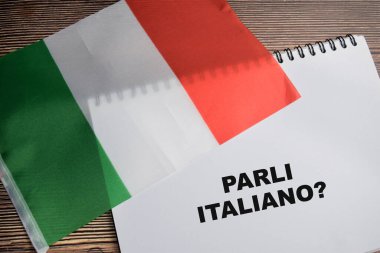 İtalya 'nın kitap ve bayrağına soru işareti ile yazılmış Parli italiano kavramı Tahta Masa' da izole edilmiştir..