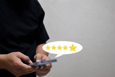Müşteri el ile akıllı telefon ekranına beş yıldızlı geri bildirim simgesi ile basılıyor ve servisi gözden geçirmek için en iyi puanı veriyor