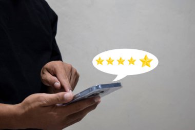 Müşteri el ile akıllı telefon ekranına beş yıldızlı geri bildirim simgesi ile basılıyor ve servisi gözden geçirmek için en iyi puanı veriyor