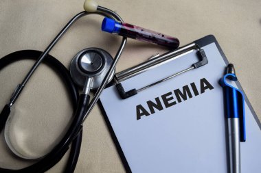 Tahta Masa 'da izole edilmiş bir panoya Anemi yazma kavramı. steteskop ve eczacılık