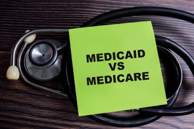 Medicaid vs Medicare kavramı Tahta Masa 'da izole edilmiş yapışkan notlar üzerine yazıldı.