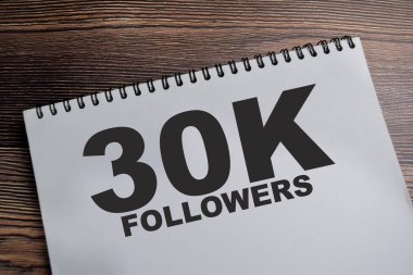 300 bin takipçi kavramı - sosyal medya platformunda 300.000 takipçiye ulaşmak - Tahta Masa 'da izole edilmiş kitap üzerine yazmak.