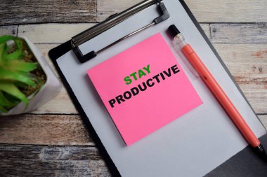 Ahşap Masa 'da izole edilmiş yapışkan notlar üzerinde üretken kalma kavramı.