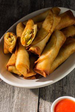 Çin tatlısı ve ekşi soslu ev yapımı börekler. Tahta bir arka planda beyaz bir tabakta