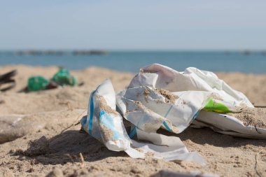 Büyük şehrin plajına çöp döküldü. Plastik. Kirli deniz. Çevre kirliliği. Ekolojik sorun.