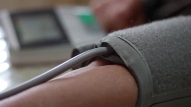 Kan basıncı monitörünü kapat. Yaşlı kadının kolunda tansiyon göstergesi var. Evde dijital tonometre kullanmak. Sağlık, hastalık tedavi kavramı.