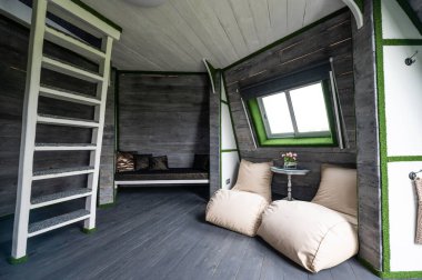 Ahşap iç tasarım. Yazlık evin oturma odası. Piramit şekilli bungalov içeriden. Zemin, duvarlar, tavanlar, ahşaptan merdivenler. Orijinal, alışılmadık, ülke iç mimarisi örnekleri tasarlıyor.