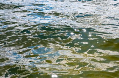 High shutter speed closeup shot of a wavy lake water flow. Deep blue black colors of the water surface.