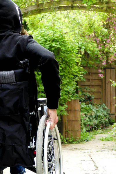 Tekerlekli Sandalyedeki Engelli Biri Bitki Örtüsü Olan Bir Sokakta Hareket — Stok fotoğraf