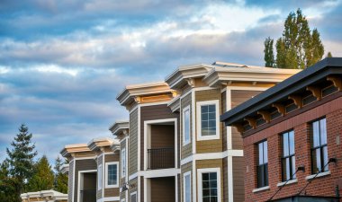 Bulutlu gökyüzü arkaplanındaki konut binasının tepesi.