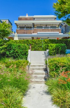 Çevreye döşenmiş ön bahçe ve merdivenlerden Trarrace 'daki iskan evine giden beton yol.