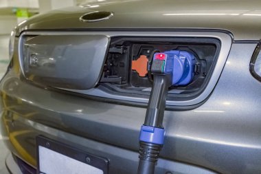 Şarj istasyonundan akü enerjisi için araca bağlı elektrik fişi.