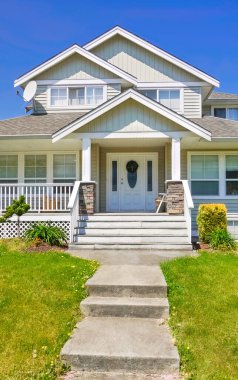 Yeşil çimlerin üzerinde beton yolu olan aile evi girişi..