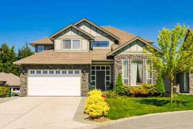 A perfect neighborhood. Big family house with concrete driveway to double size garage. Residential house entrance with landscaped front yard